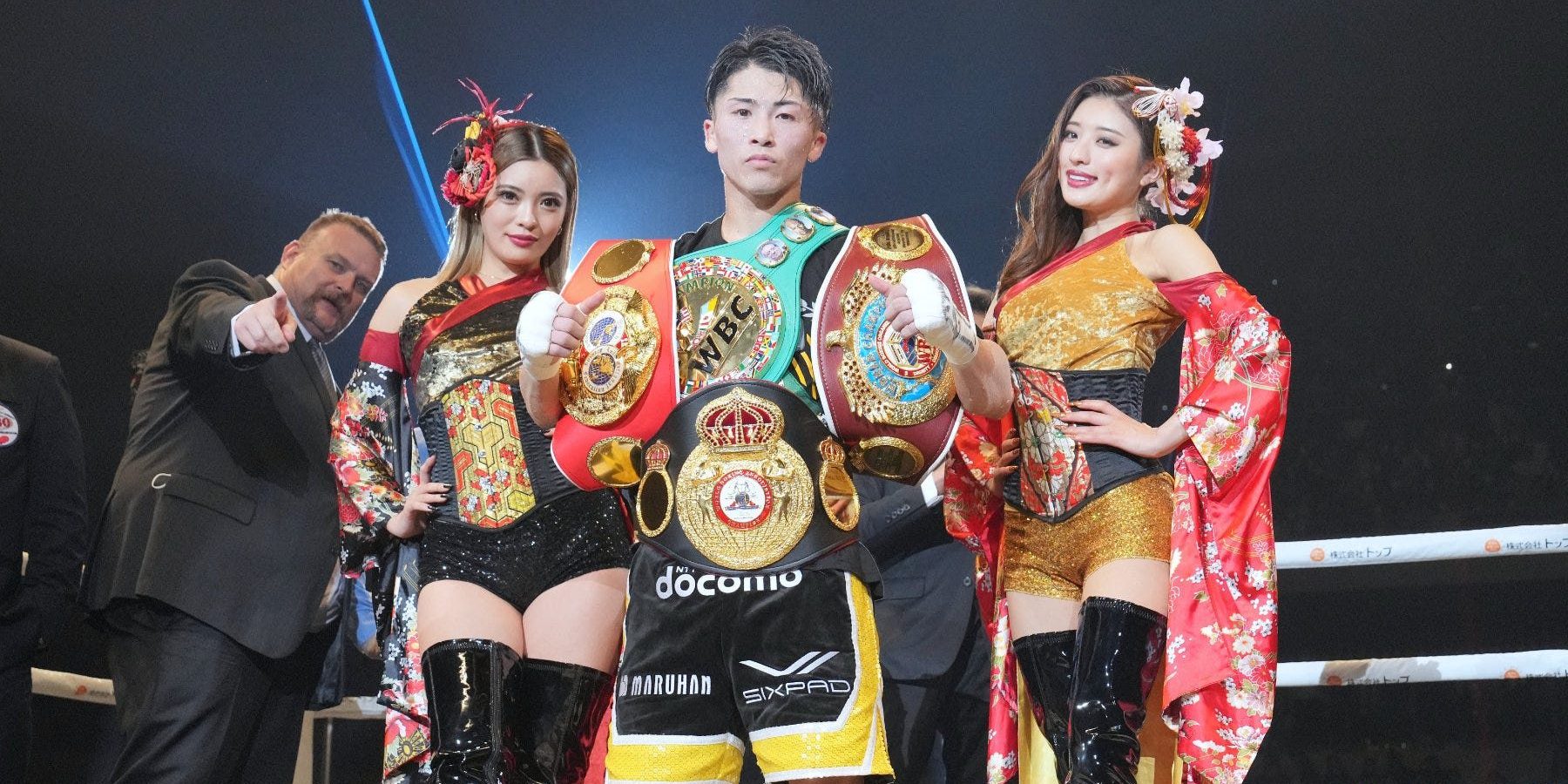 Naoya inoue con edecanes y cuatro cinturones