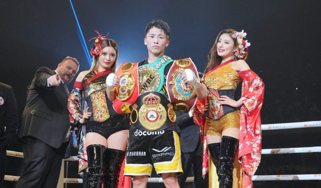Naoya inoue con edecanes y cuatro cinturones
