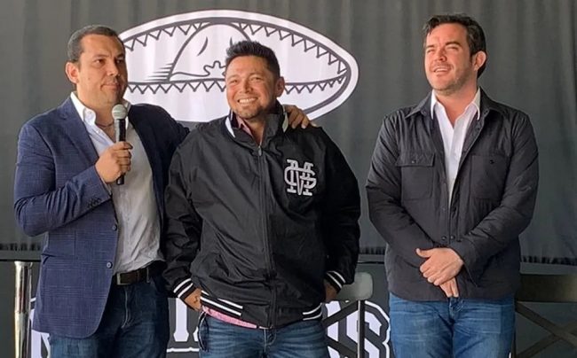 Luis Borges, abrazado por el Presidente de los Mariachis, Rafael Tejeda y por el también directivo, Carlos Valenzuela, el día de su presentación, del 030323 en estadio panamericano de Guadalajara